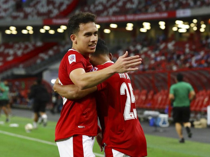 Egy Maulana Vikri of Indonesia, left, celebrates with Irfan Samaling Kumi of Indonesia after scoring the fourth goal during the AFF Suzuki Cup 2020 semi-final second leg match between Indonesia and Singapore in Singapore, Saturday, Dec. 25, 2021. (AP Photo/Suhaimi Abdullah)
