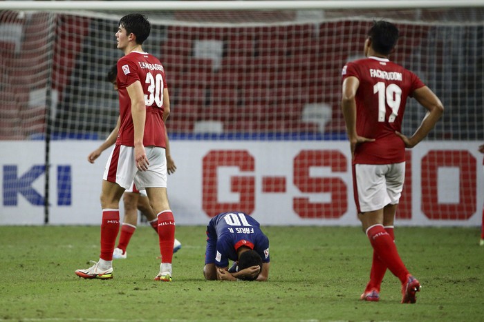 Faris Ramli of Singapore, center, reacts at the final whistle during the AFF Suzuki Cup 2020 semi-final second leg match between Indonesia and Singapore in Singapore, Saturday, Dec. 25, 2021. (AP Photo/Suhaimi Abdullah)