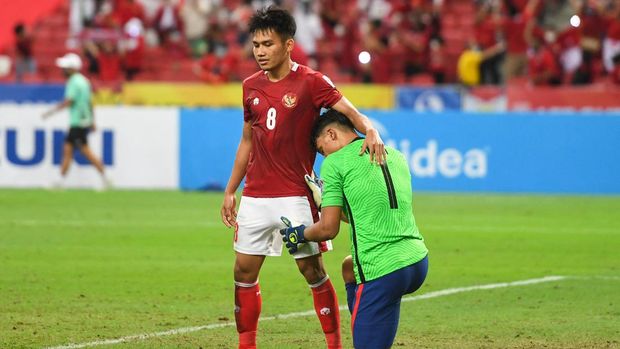 Indonesia's Witan Sulaeman (L) consoles Singapore's Ikhsan Fandi after the second leg of the AFF Suzuki Cup 2020 football semi-final match between Singapore and Indonesia at the National Stadium in Singapore on December 25, 2021. (Photo by Roslan RAHMAN / AFP)