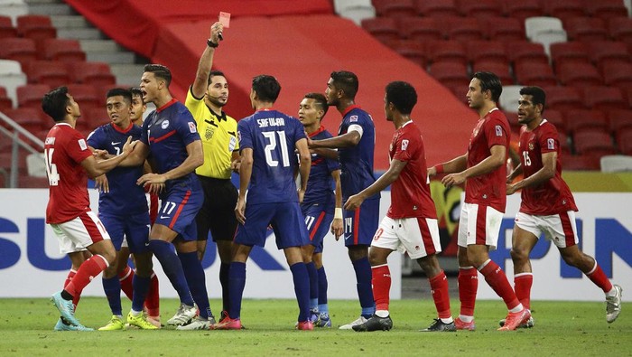 Players scuffle as Safuwan Baharudin of Singapore, center, gets a red card during the AFF Suzuki Cup 2020 semi-final second leg match between Indonesia and Singapore in Singapore, Saturday, Dec. 25, 2021. (AP Photo/Suhaimi Abdullah)