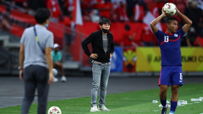 SINGAPORE, SINGAPORE - DECEMBER 25: Head coach Shin Tae-Yong (C) of Indonesia looks on as Zulqarnaen Suzliman #13 of Singapore prepares for a throw-in during the first half of the second leg of their AFF Suzuki Cup semifinal at the National Stadium on December 25, 2021 in Singapore. (Photo by Yong Teck Lim/Getty Images)
