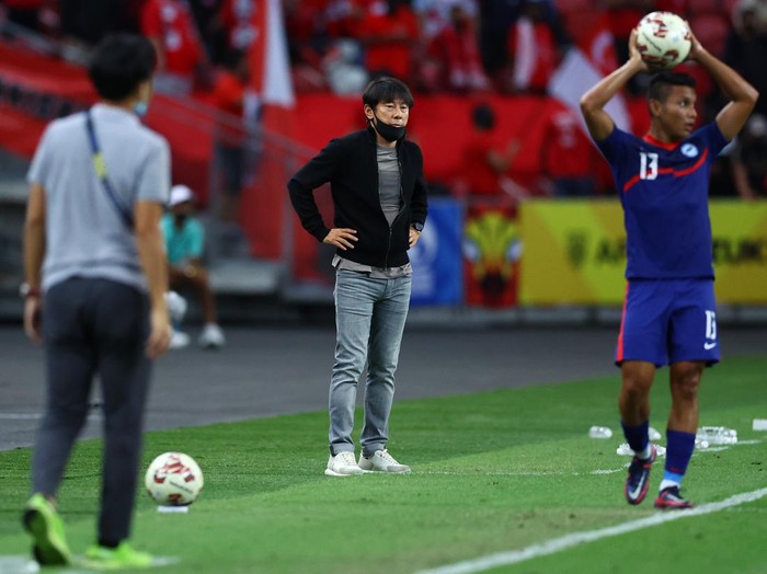 SINGAPORE, SINGAPORE - DECEMBER 25: Head coach Shin Tae-Yong (C) of Indonesia looks on as Zulqarnaen Suzliman #13 of Singapore prepares for a throw-in during the first half of the second leg of their AFF Suzuki Cup semifinal at the National Stadium on December 25, 2021 in Singapore. (Photo by Yong Teck Lim/Getty Images)