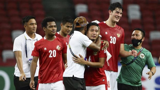Asnawi Mangkualam of Indonesia, front right, celebrates with teammates and officialsafter defeating Singapore during the AFF Suzuki Cup 2020 semi-final second leg match between Indonesia and Singapore in Singapore, Saturday, Dec. 25, 2021. (AP Photo/Suhaimi Abdullah)