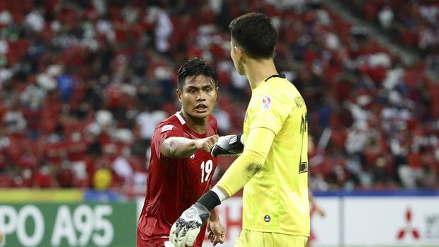 Fachruddin Aryanto of Indonesia, left, fist bump Nadeo Arga Winata of Indonesia before the penalty kick by Singapore during the AFF Suzuki Cup 2020 semi-final second leg match between Indonesia and Singapore in Singapore, Sunday, Dec. 26, 2021. (AP Photo/Suhaimi Abdullah)
