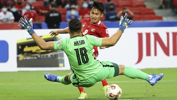 Hassan Sunny of Singapore, foreground, attempts a block on Witan Sulaeman of Indonesia cross during the AFF Suzuki Cup 2020 semi-final second leg match between Indonesia and Singapore in Singapore, Sunday, Dec. 26, 2021. (AP Photo/Suhaimi Abdullah)