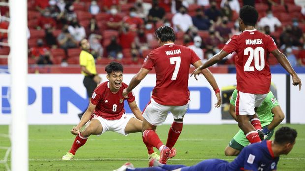 Singapore Soccer Suzuki Cup Witan Sulaeman of Indonesia, left, celebrates with Ezra Harm Ruud Walian, second left, after scoring the first goal during the AFF Suzuki Cup 2020 semi-final second leg match between Indonesia and Singapore in Singapore, Saturday, Dec. 25, 2021. (AP Photo/Suhaimi Abdullah)