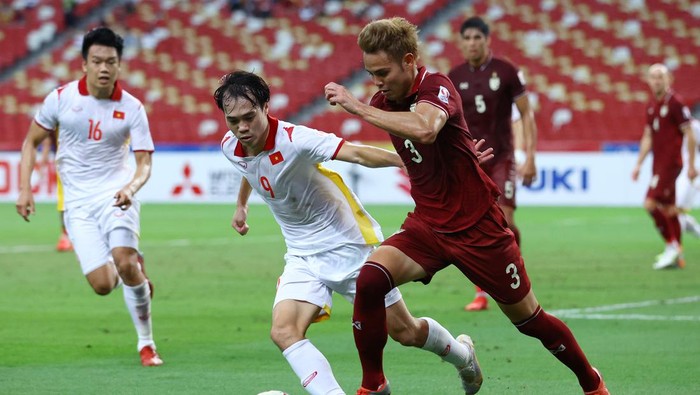 SINGAPORE, SINGAPORE - DECEMBER 26: Theerathon Bunmathan #3 of Thailand controls the ball against Nguyen Van Toan #9 of Vietnam during the second half of the second leg of their AFF Suzuki Cup semifinal at the National Stadium on December 26, 2021 in Singapore. (Photo by Yong Teck Lim/Getty Images)