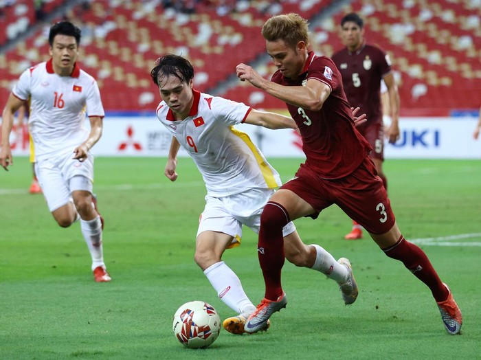 SINGAPORE, SINGAPORE - DECEMBER 26: Theerathon Bunmathan #3 of Thailand controls the ball against Nguyen Van Toan #9 of Vietnam during the second half of the second leg of their AFF Suzuki Cup semifinal at the National Stadium on December 26, 2021 in Singapore. (Photo by Yong Teck Lim/Getty Images)