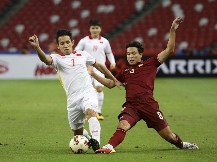 Thitipan Puangjan, of Thailand, right, and Nguyen Phong Hong Duy, of Vietnam, compete for the ball during the AFF Suzuki Cup 2020 semi-final second leg match between Thailand and Vietnam in Singapore, Sunday, Dec. 26, 2021. (AP Photo/Suhaimi Abdullah)