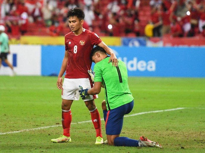Indonesias Witan Sulaeman (L) consoles Singapores Ikhsan Fandi after the second leg of the AFF Suzuki Cup 2020 football semi-final match between Singapore and Indonesia at the National Stadium in Singapore on December 25, 2021. (Photo by Roslan RAHMAN / AFP)