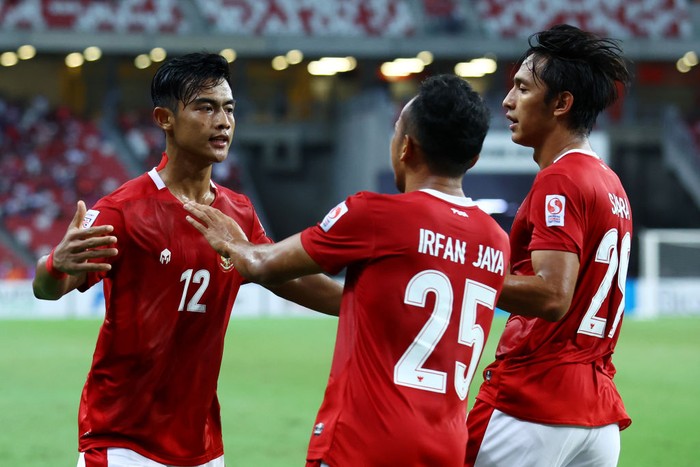 SINGAPORE, SINGAPORE - DECEMBER 25: Pratama Arhan Alif Rifai #12 of Indonesia celebrates with teammates Irfan Samaling Kumi #25 and Hanis Saghara Putra #29 after scoring their second goal against Singapore during the second half of the second leg of their AFF Suzuki Cup semifinal at the National Stadium on December 25, 2021 in Singapore. (Photo by Yong Teck Lim/Getty Images)