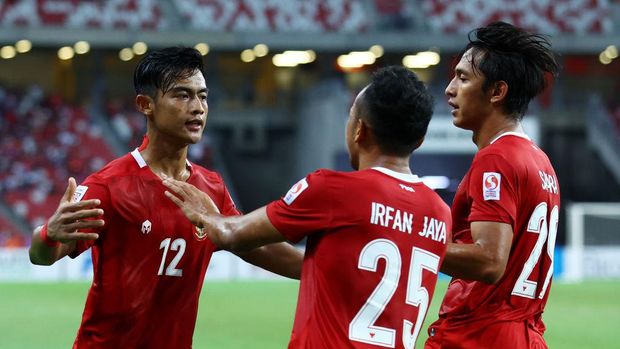 SINGAPORE, SINGAPORE - DECEMBER 25: Pratama Arhan Alif Rifai #12 of Indonesia celebrates with teammates Irfan Samaling Kumi #25 and Hanis Saghara Putra #29 after scoring their second goal against Singapore during the second half of the second leg of their AFF Suzuki Cup semifinal at the National Stadium on December 25, 2021 in Singapore. (Photo by Yong Teck Lim/Getty Images)