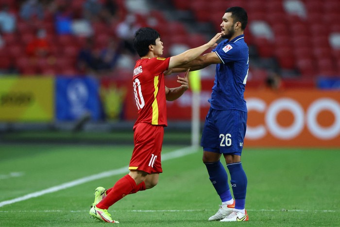 SINGAPORE, SINGAPORE - DECEMBER 23: Nguyen Cong Phuong #10 of Vietnam and Kritsada Kaman #26 of Thailand scuffle during the first half of the first leg of their AFF Suzuki Cup semifinal at the National Stadium on December 23, 2021 in Singapore. (Photo by Yong Teck Lim/Getty Images)