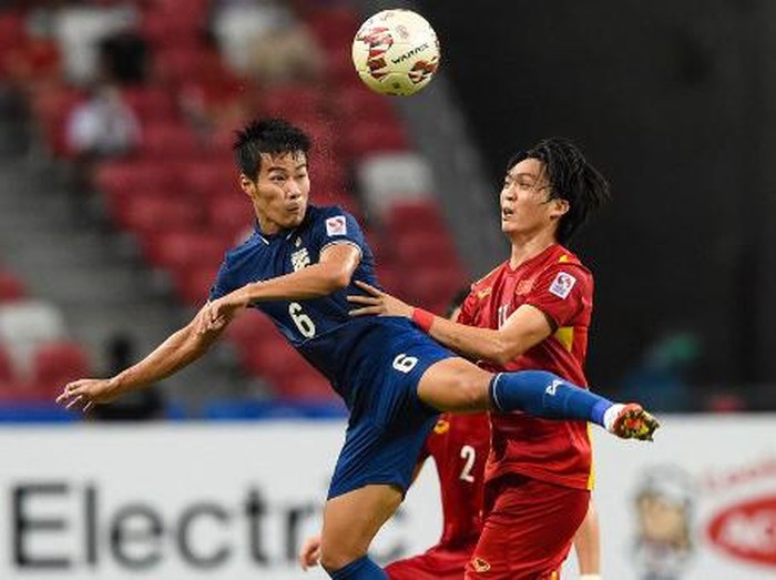 Thailand's Sarach Yooyen (L) fights for the ball with Vietnam's Nguyen Tuan Anh during the first leg of the AFF Suzuki Cup 2020 football semi-final match between Vietnam and Thailand at the National Stadium in Singapore on December 23, 2021. (Photo by Roslan RAHMAN / AFP)