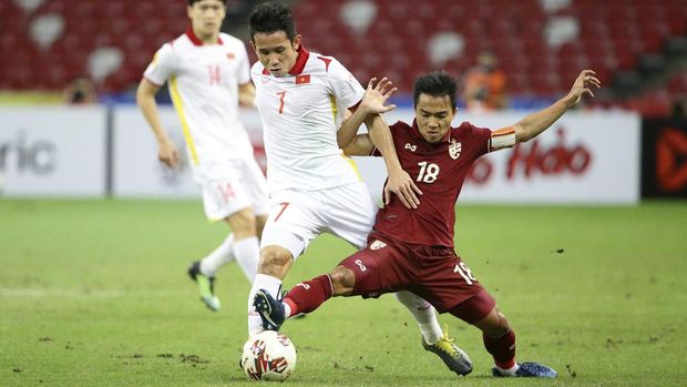Nguyen Phong Hong Duy, of Vietnam, left, and Chanathip Songkrasin, of Thailand, compete for the ball during the AFF Suzuki Cup 2020 semi-final second leg match between Thailand and Vietnam, in Singapore, Sunday, Dec. 26, 2021. (AP Photo/Suhaimi Abdullah)