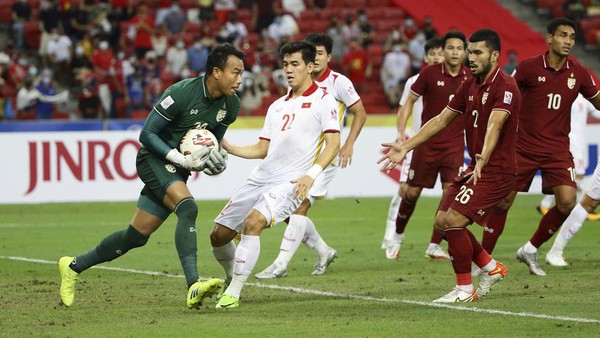 Goalkeeper Chatchai Bootprom of Thailand, left, saves the ball under pressure from Nguyen Tien Linh of Vietnam, during the AFF Suzuki Cup 2020 semi-final second leg match between Thailand and Vietnam in Singapore, Sunday, Dec. 26, 2021. (AP Photo/Suhaimi Abdullah)