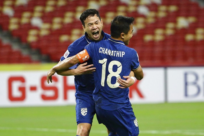 Chanathip Songkrasin of Thailand, foreground, celebrates with Thanawat Suengchitthawon after scoring the first goal during the AFF Suzuki Cup 2020 semi-final first leg match between Vietnam and Thailand in Singapore, Thursday, Dec. 23, 2021. (AP Photo/Suhaimi Abdullah)