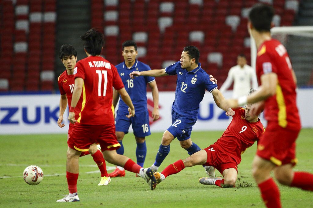 Chanathip Songkrasin of Thailand, foreground, celebrates with Thanawat Suengchitthawon after scoring the first goal during the AFF Suzuki Cup 2020 semi-final first leg match between Vietnam and Thailand in Singapore, Thursday, Dec. 23, 2021. (AP Photo/Suhaimi Abdullah)