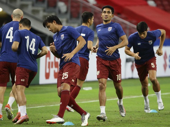 Teerasil Dangda of Thailand, second right, warms up on the pitch ahead of the AFF Suzuki Cup 2020 semi-final second leg match between Thailand and Vietnam in Singapore, Sunday, Dec. 26, 2021. (AP Photo/Suhaimi Abdullah)