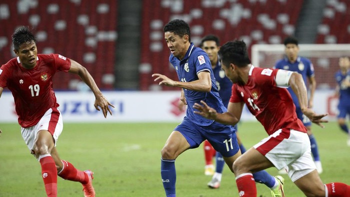 Supachok Sarachat of Thailand, right, controls the ball against Rachmat Irianto of Indonesia during the AFF Suzuki Cup 2020 final first leg soccer match between Indonesia and Thailand in Singapore, Wednesday, Dec. 29, 2021. (AP Photo/Suhaimi Abdullah)
