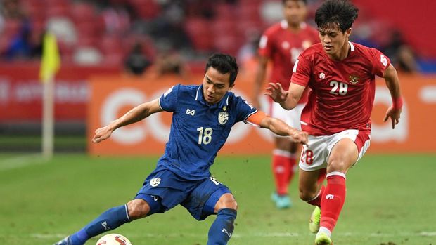 Thailand's Chanathip Songkrasin (L) fights for the ball with Indonesia's Alfeandra Dewangga Santosa during the first leg of the AFF Suzuki Cup 2020 football final match between Indonesia and Thailand at the National Stadium in Singapore on December 29, 2021. (Photo by Roslan RAHMAN / AFP)