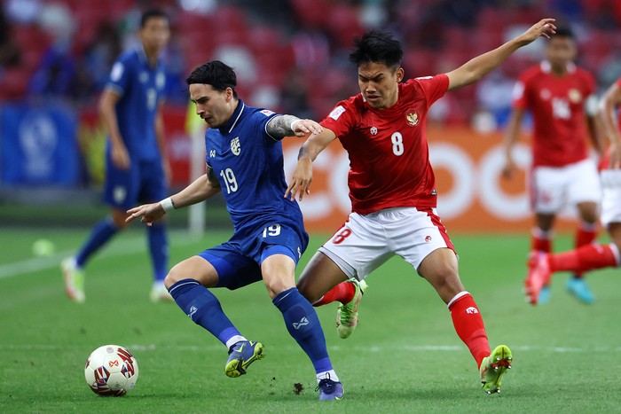 SINGAPORE, SINGAPORE - DECEMBER 29: Tristan Do #19 of Thailand controls the ball against Witan Sulaeman #8 of Indonesia in the first half during the first leg of the AFF Suzuki Cup final at the National Stadium on December 29, 2021 in Singapore. (Photo by Yong Teck Lim/Getty Images)
