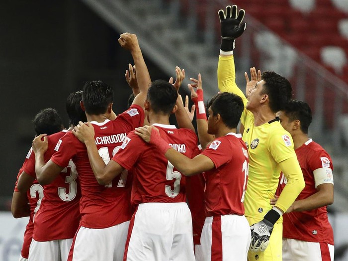 Indonesia players huddle during the AFF Suzuki Cup 2020 final first leg soccer match between Indonesia and Thailand in Singapore, Wednesday, Dec. 29, 2021. (AP Photo/Suhaimi Abdullah)