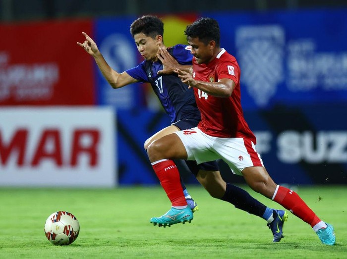SINGAPORE, SINGAPORE - DECEMBER 09: Asnawi Mangkualam Bahar #14 of Indonesia competes for the ball against Lim Pisoth #17 of Cambodia during the first half of their AFF Suzuki Cup Group B game at Bishan Stadium on December 09, 2021 in Singapore. (Photo by Yong Teck Lim/Getty Images)