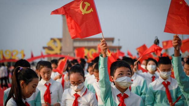 A student waves the flag of Communist Party of China before the celebrations marking the 100th anniversary of the founding of the Communist Party of China in Beijing on July 1, 2021. (Photo by WANG Zhao / AFP)