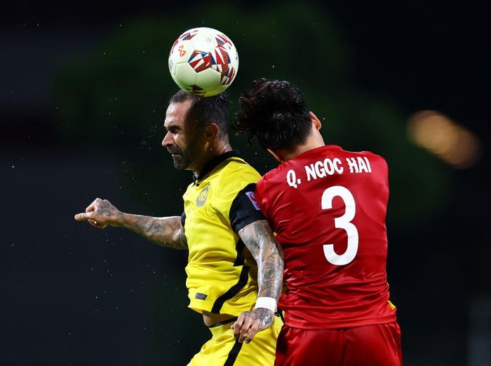 SINGAPORE, SINGAPORE - DECEMBER 14: Paulo Domingos Gali #21 of Timor-Leste shoots the ball against Irfan Fandi #17 and Safuwan Baharudin #21 of Singapore during the second half of their AFF Suzuki Cup Group A game at the National Stadium on December 14, 2021 in Singapore. (Photo by Yong Teck Lim/Getty Images)