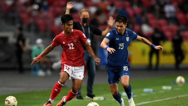 Indonesia's Pratama Arhan Alif Rifai (L) fights for the ball with Thailand's Narubadin Weerawatnodom during the second leg of the AFF Suzuki Cup 2020 football final match between Thailand and Indonesia at the National Stadium in Singapore on January 1, 2022. (Photo by Roslan RAHMAN / AFP)