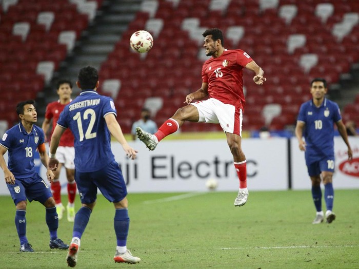 Ricky Richardo Kambuaya of Indonesia, second right, jumps for the ball during the AFF Suzuki Cup 2020 final second leg match between Thailand and Indonesia in Singapore, Saturday, Jan. 1, 2022. (AP Photo/Suhaimi Abdullah)