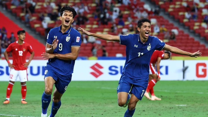 SINGAPORE, SINGAPORE - JANUARY 01: Adisak Kraisorn #9 of Thailand celebrates with Bordin Phala #11 after scoring their first goal against Indonesia in the second half during the second leg of the AFF Suzuki Cup final at the National Stadium on January 01, 2022 in Singapore. (Photo by Yong Teck Lim/Getty Images)
