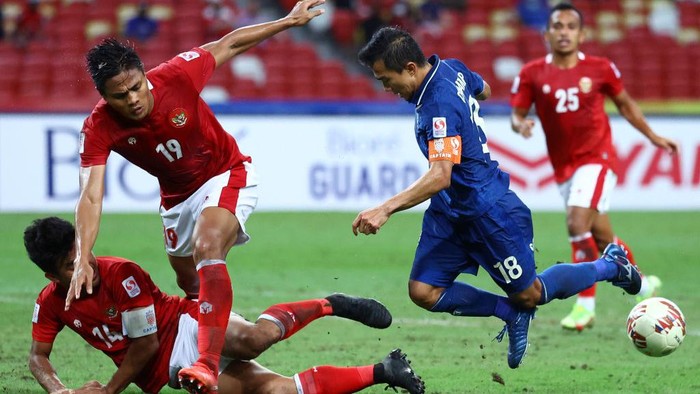 SINGAPORE, SINGAPORE - JANUARY 01: Adisak Kraisorn #9 of Thailand celebrates with his teammates after scoring their first goal against Indonesia in the second half during the second leg of the AFF Suzuki Cup final at the National Stadium on January 01, 2022 in Singapore. (Photo by Yong Teck Lim/Getty Images)