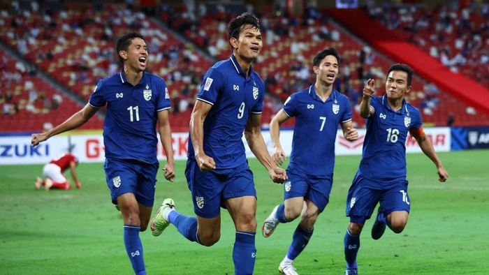 SINGAPORE, SINGAPORE - JANUARY 01: Adisak Kraisorn #9 of Thailand celebrates with his teammates after scoring their first goal against Indonesia in the second half during the second leg of the AFF Suzuki Cup final at the National Stadium on January 01, 2022 in Singapore. (Photo by Yong Teck Lim/Getty Images)