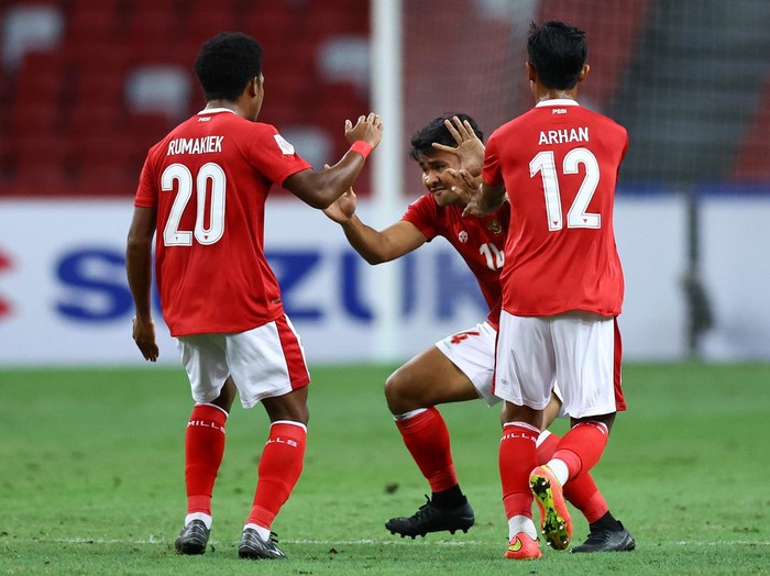 SINGAPORE, SINGAPORE - JANUARY 01: (L-R) Ramai Melvin Rumakiek #20, Asnawi Mangkualam Bahar #14 and Pratama Arhan Alif Rifai #12 of Indonesia celebrate a goal by teammate Ricky Richardo Kambuaya #15 (not pictured) against Thailand in the first half during the second leg of the AFF Suzuki Cup final at the National Stadium on January 01, 2022 in Singapore. (Photo by Yong Teck Lim/Getty Images)