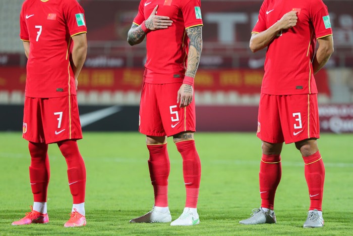 SHARJAH, UNITED ARAB EMIRATES - JUNE 15: Wu Lei, Zhang Linpeng and Wang Shenchao stand for the national anthem during the 2022 FIFA World Cup Asian Qualifiers Group A between China and Syria at Sharjah Stadium on June 15, 2021 in Sharjah, United Arab Emirates.  (Photo by Neville Hopwood/Getty Images)