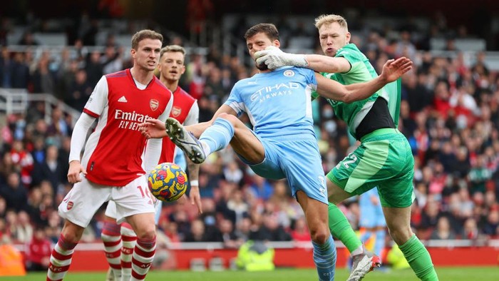 LONDON, ENGLAND - JANUARY 01: Aaron Ramsdale of Arsenal and Ruben Dias of Manchester City collide during the Premier League match between Arsenal  and  Manchester City at Emirates Stadium on January 01, 2022 in London, England. (Photo by Catherine Ivill/Getty Images)