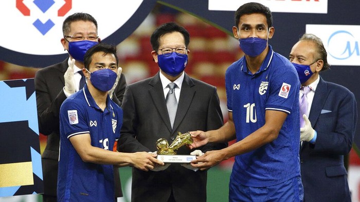 Chanathip Songkrasin of Thailand, left, and Teerasil Dangda of Thailand, right, receive the Golden Boot Award during the AFF Suzuki Cup 2020 final second leg match between Thailand and Indonesia in Singapore, Saturday, Jan. 1, 2022. (AP Photo/Suhaimi Abdullah)