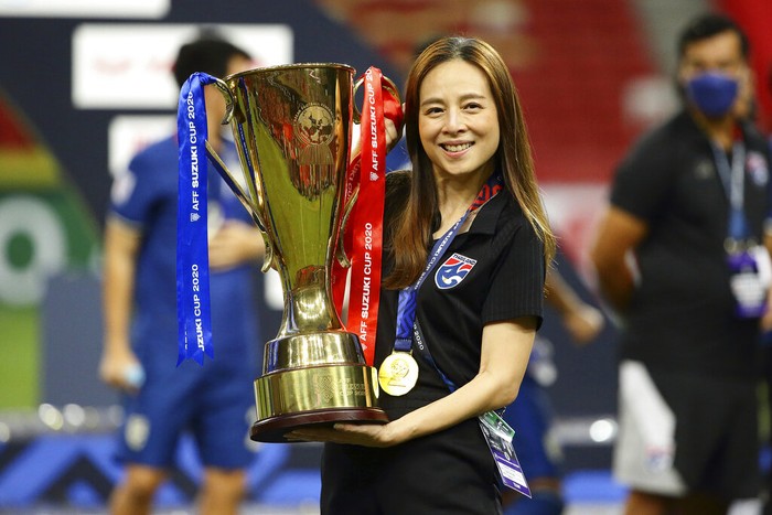 Thailand team manager, Nualphan Lamsam poses with the trophy after Thailand defeat Indonesia in the AFF Suzuki Cup 2020 final second leg soccer match in Singapore, Saturday, Jan. 1, 2022. (AP Photo/Suhaimi Abdullah)