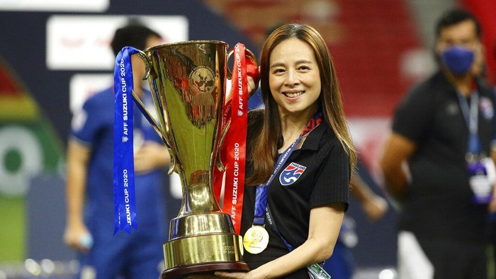 Thailand team manager, Nualphan Lamsam poses with the trophy after Thailand defeat Indonesia in the AFF Suzuki Cup 2020 final second leg soccer match in Singapore, Saturday, Jan. 1, 2022. (AP Photo/Suhaimi Abdullah)