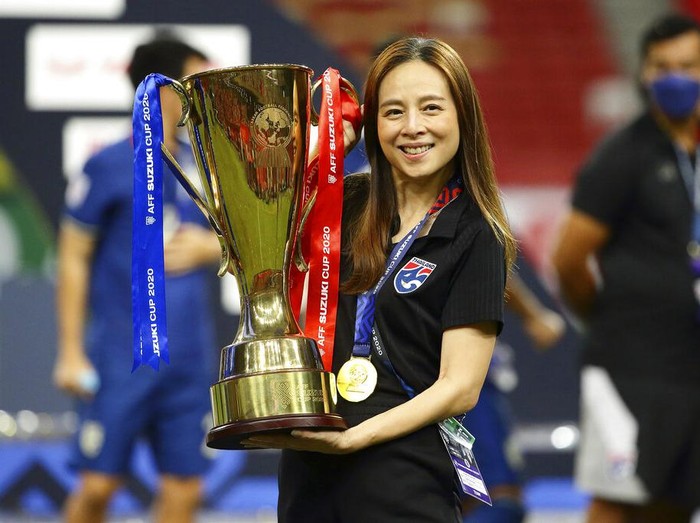 Thailand team manager, Nualphan Lamsam poses with the trophy after Thailand defeat Indonesia in the AFF Suzuki Cup 2020 final second leg soccer match in Singapore, Saturday, Jan. 1, 2022. (AP Photo/Suhaimi Abdullah)