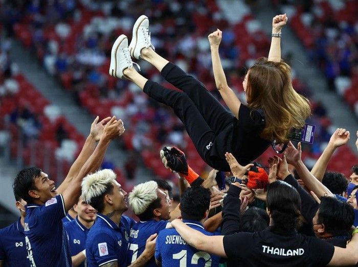 SINGAPORE, SINGAPORE - JANUARY 01: The Thai team celebrates with their team manager Nualphan Lamsam after winning the AFF Suzuki Cup final against Indonesia at the National Stadium on January 01, 2022 in Singapore. Thailand won 6-2 on aggregate. (Photo by Yong Teck Lim/Getty Images)
