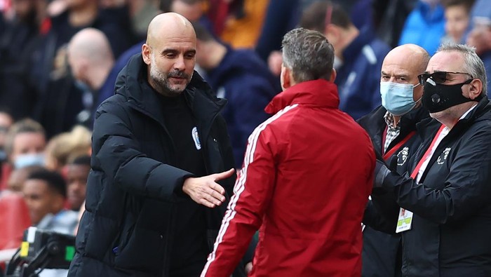 LONDON, ENGLAND - JANUARY 01: Pep Guardiola, Manager of Manchester City shakes hands with Arsenal Assistant Manager Albert Stuivenberg prior to the Premier League match between Arsenal and Manchester City at Emirates Stadium on January 01, 2022 in London, England. (Photo by Julian Finney/Getty Images)
