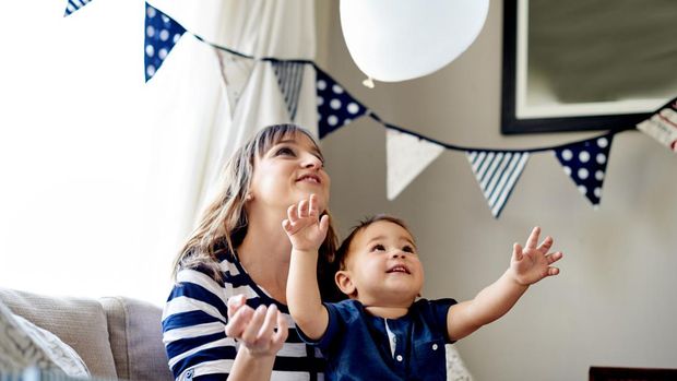 Shot of a mother and son playing with a balloon on his first birthday at home