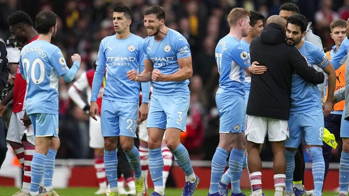 Manchester Citys Ruben Dias, center, and his teammates celebrate after the Premier League soccer match between Arsenal and Manchester City at the Emirates Stadium, in London, England, Saturday Jan. 1, 2022. (AP Photo/Matt Dunham)