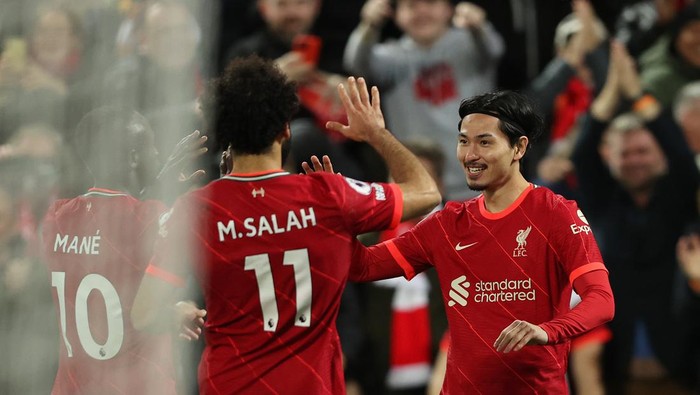 LIVERPOOL, ENGLAND - NOVEMBER 20: Takumi Minamino celebrates with teammates Mohamed Salah and Sadio Mane of Liverpool after scoring their teams fourth goal during the Premier League match between Liverpool and Arsenal at Anfield on November 20, 2021 in Liverpool, England. (Photo by Clive Brunskill/Getty Images)