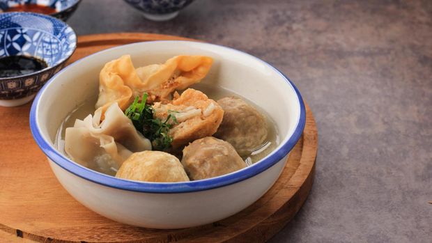 bakso Bakso Arema, Meatballs Food Special from Malang East Java Indonesia. Close Up, on Wooden Board and Rustic Table. Served with SOy Sauce, Sauce, and Chilli Paste