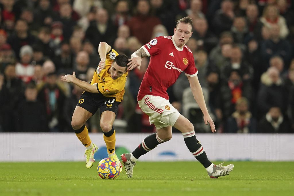Manchester United's Phil Jones, right, challenges for the ball with Wolverhampton Wanderers' Daniel Podence during the English Premier League soccer match between Manchester United and Wolverhampton Wanderers at Old Trafford stadium in Manchester, England, Monday, Jan.3, 2022. (AP Photo/Dave Thompson)