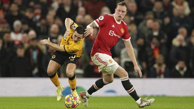Manchester United's Phil Jones, right, challenges for the ball with Wolverhampton Wanderers' Daniel Podence during the English Premier League soccer match between Manchester United and Wolverhampton Wanderers at Old Trafford stadium in Manchester, England, Monday, Jan.3, 2022. (AP Photo/Dave Thompson)